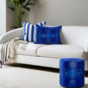 Cobalt blue velvet rectangular cushion and with a cobalt blue ottoman styled with a striped blue and white cushion and throw.