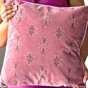 Rose taupe velvet cushion held by a person.