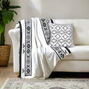 Black and white savanna  velvet throw styled with a black and white patterned cushion. 