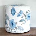 White velour fabric round ottoman with blue hibiscus floral pattern design . 