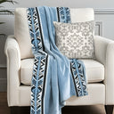 Blue savanna throw and Ivory and black cushion, styled on a white armchair. 