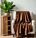 Copper brown tartan velvet throw blanket. Styled on a white sofa with. 