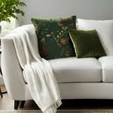 Emerald green and gold velvet cushion styled with a matching cushion and throw
