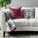 Grey magnolia cushion styled with a contrasting burgundy cushion and a matching throw. 