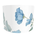 Hibiscus Blue lampshade features a classic white drum shape adorned with a delicate blue hibiscus pattern. Side. 