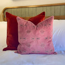 Rose taupe cushion styled on white bedding paired with a copper velvet cushion.
