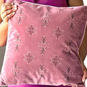 Rose taupe velvet cushion held by a person.