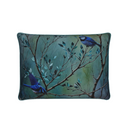 Decorative pillow with bird and branch design on a teal background.