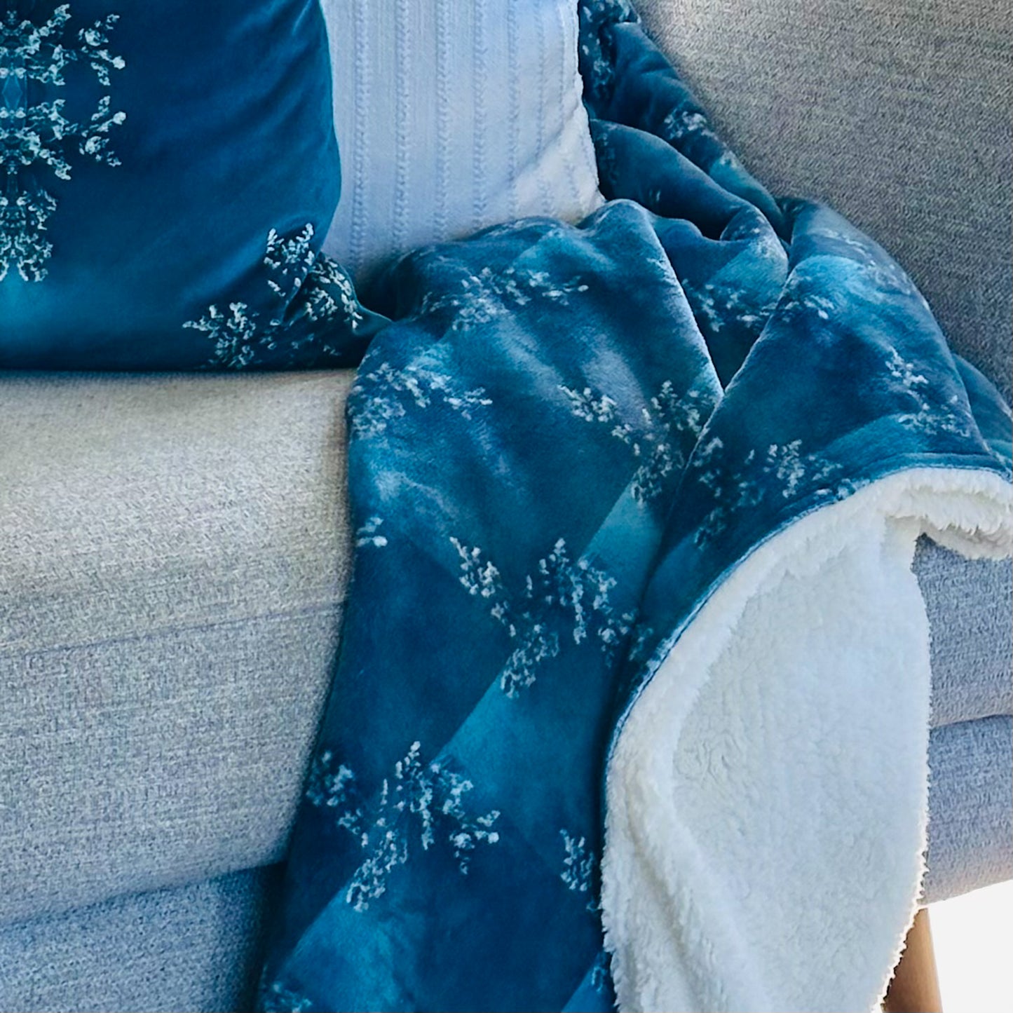 Teal Velvet Throw. Soft velvet front, Sherpa fleece backing. Soft armchair blanket styled on a grey sofa. 