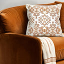 Terracota Velvet cushion styled on copper brown sofa with a cream throw.